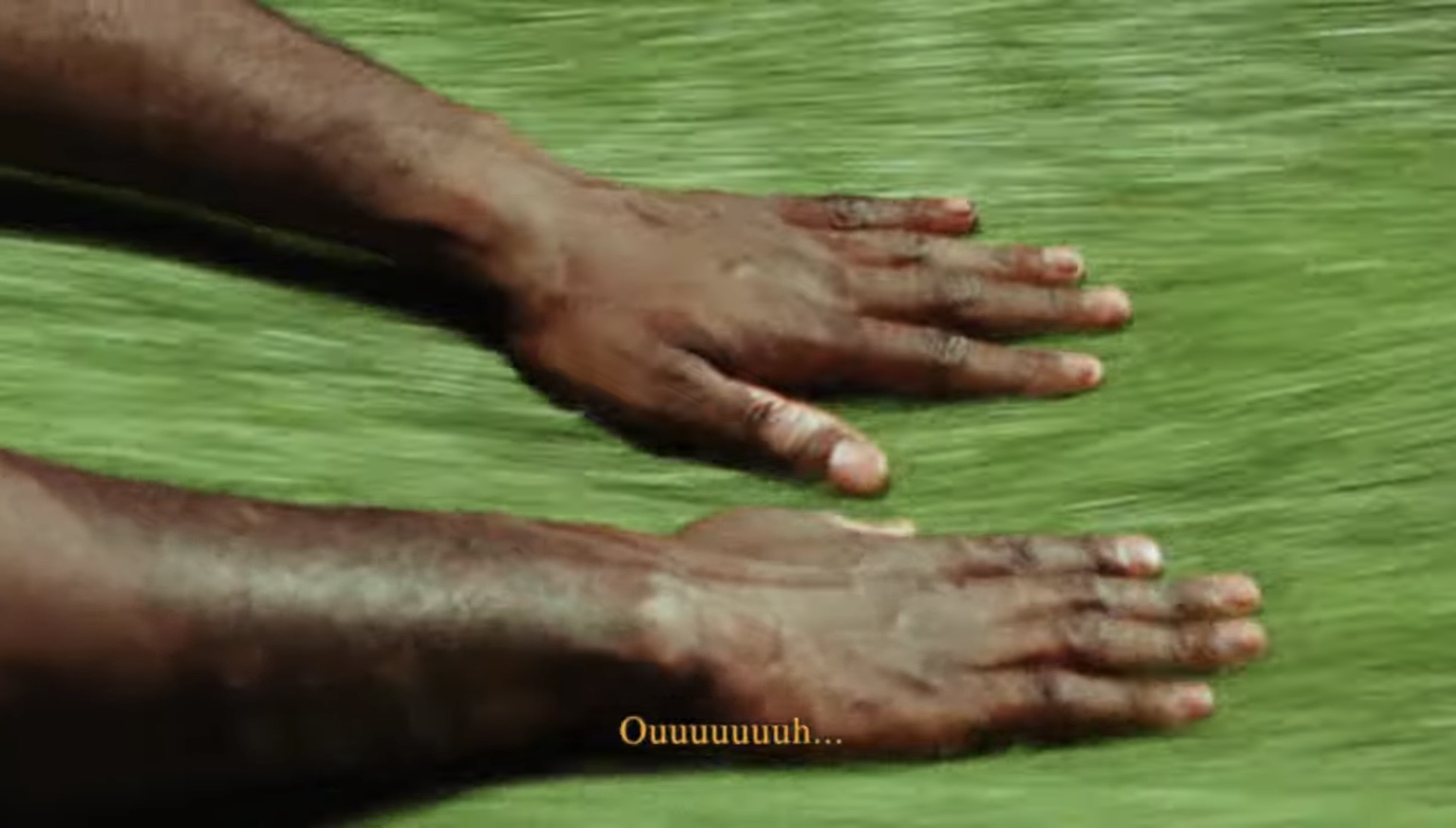 Hands resting over green grass