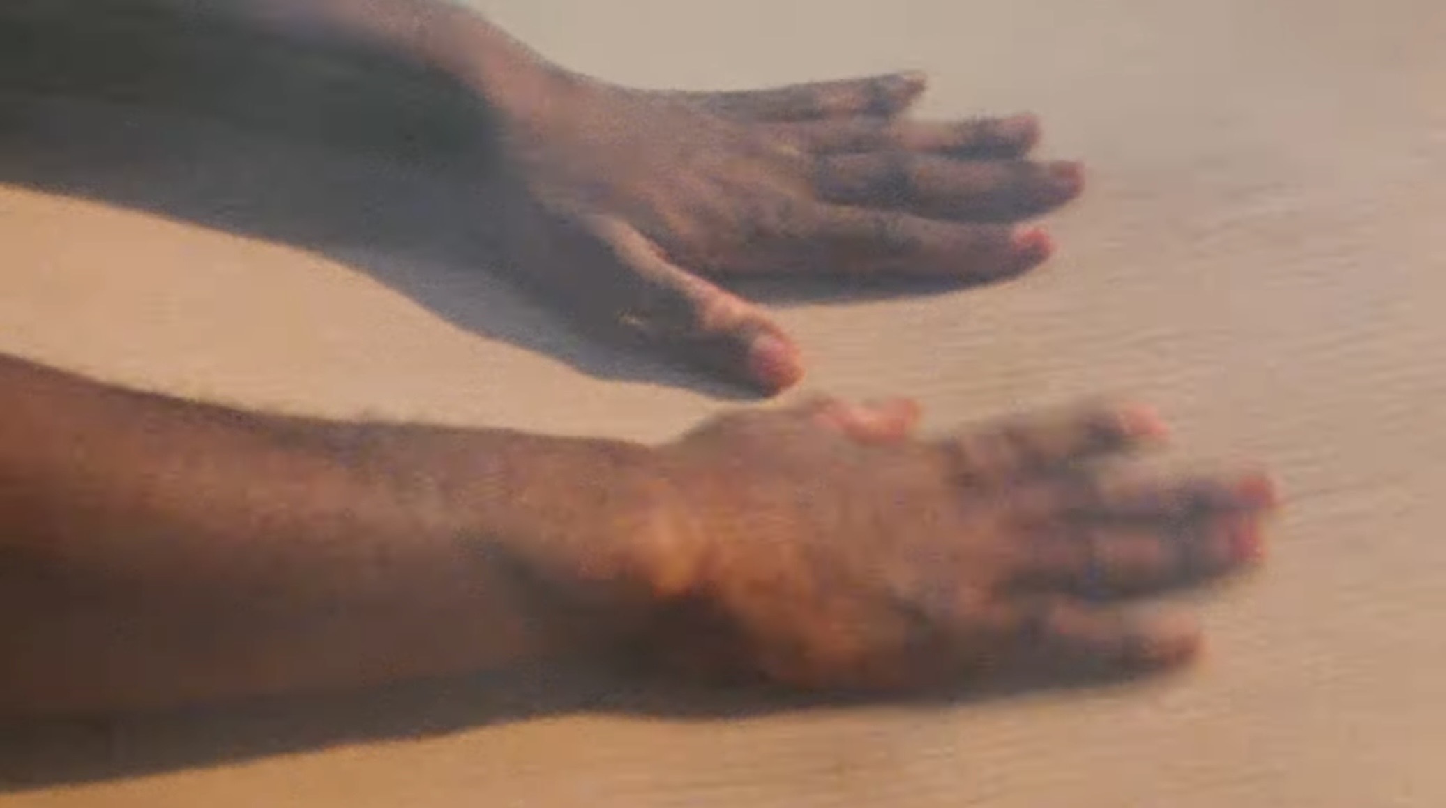 Hands moving across sand dunes
