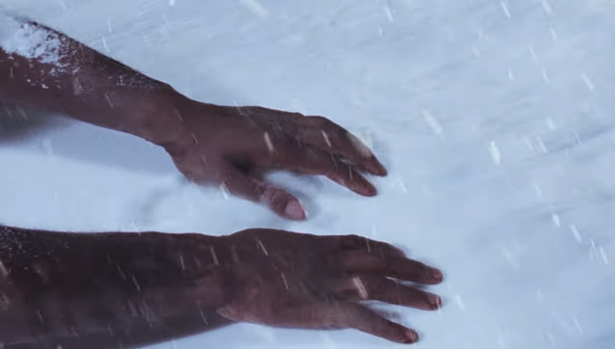 Hands crossing a snowfield